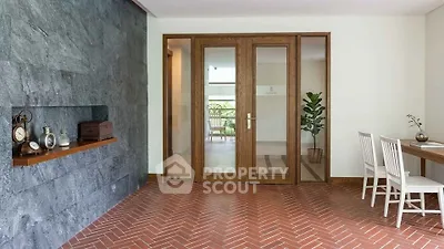 Elegant entrance with brick flooring and wooden doors leading to a bright interior, perfect for modern living.