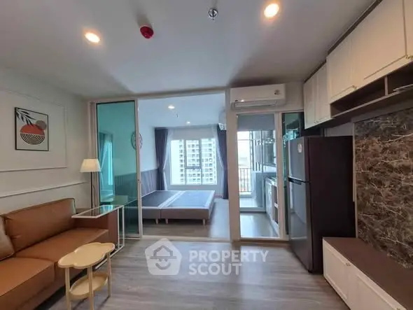 Modern apartment interior with open layout, featuring living room and bedroom with large windows.