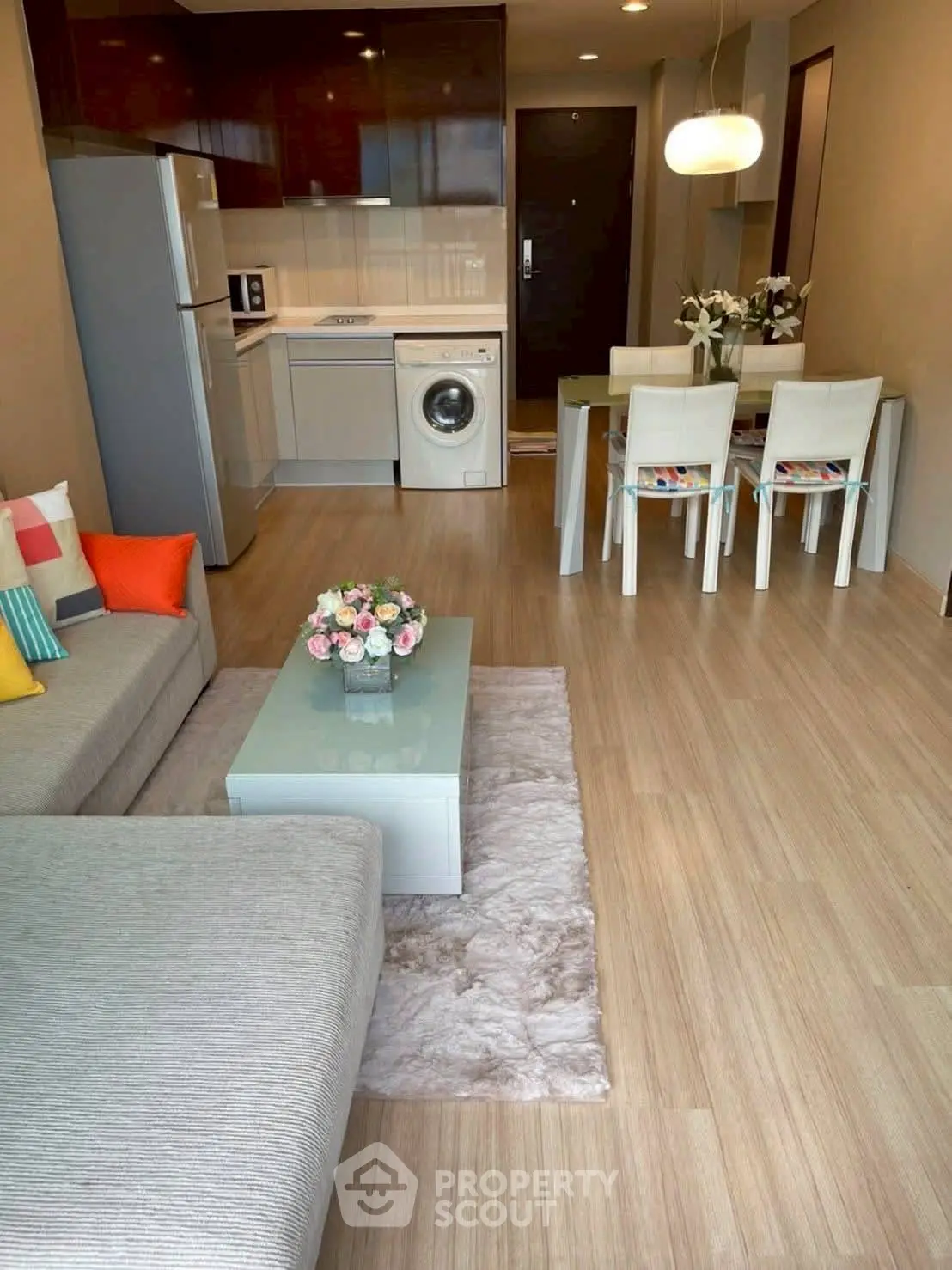 Modern open-plan living room with kitchen, featuring stylish furniture and appliances.