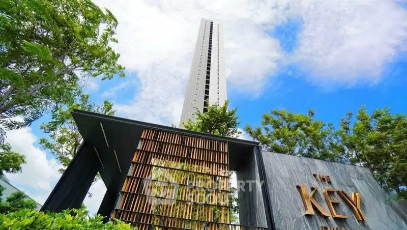 Stunning modern high-rise building with lush greenery and clear blue sky.