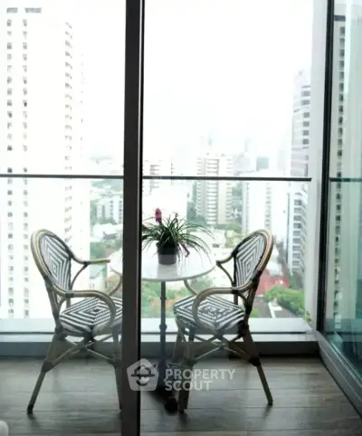 Chic balcony with city view, featuring stylish outdoor seating and glass railing, perfect for urban living.