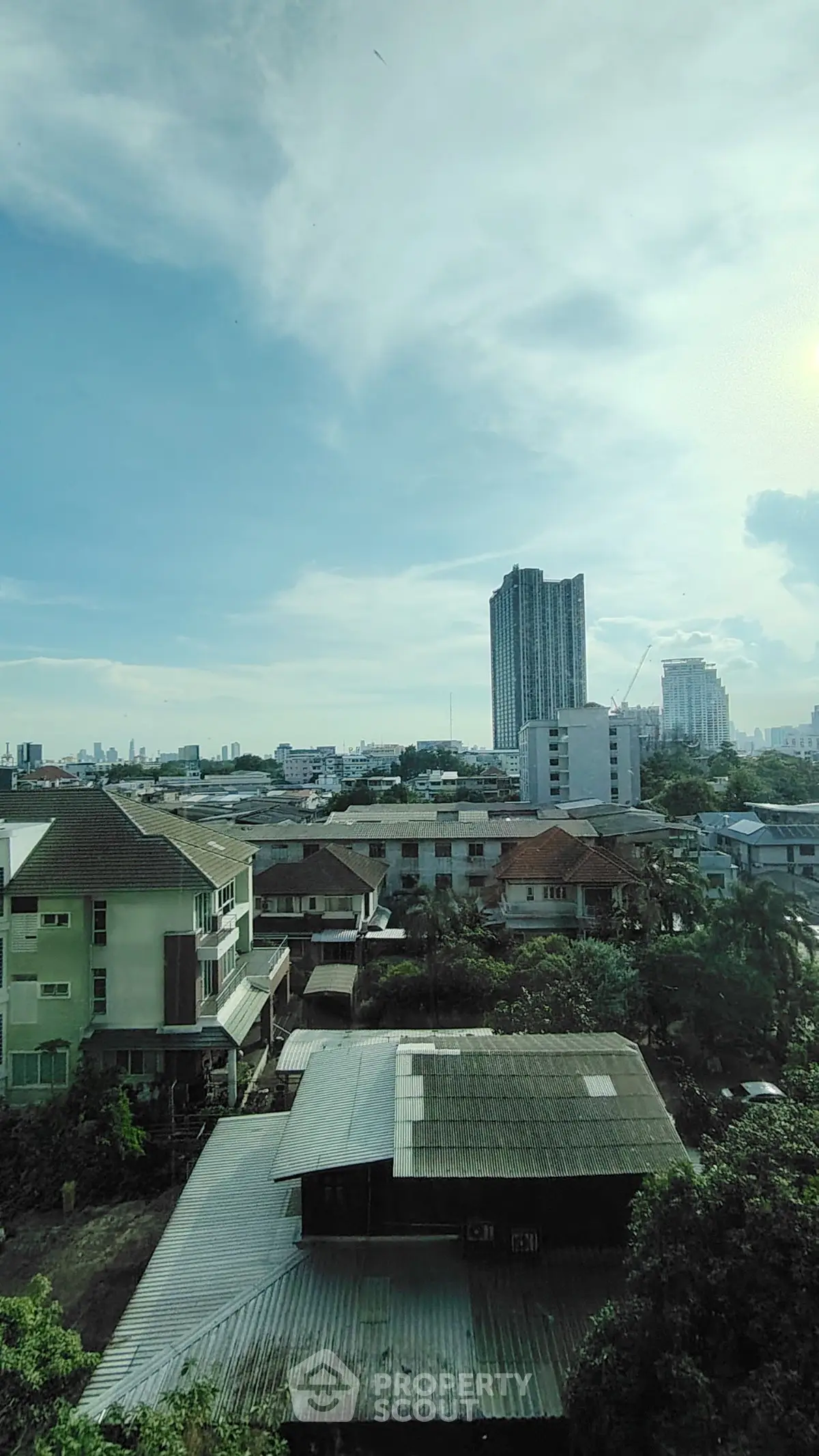Stunning cityscape view with modern high-rise and charming residential area, perfect for urban living.