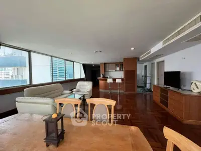 Spacious living room with modern furniture and large windows offering city views.