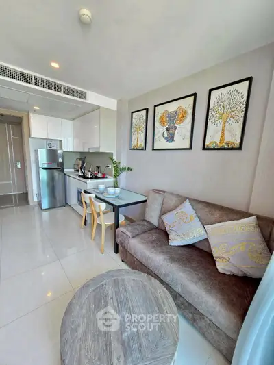 Modern living room with open kitchen, cozy sofa, and stylish decor in a bright apartment.