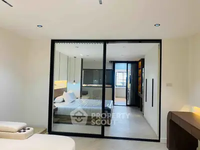 Modern bedroom with sliding glass doors and elegant furnishings