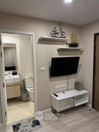 Modern apartment interior with wall-mounted TV and bathroom view