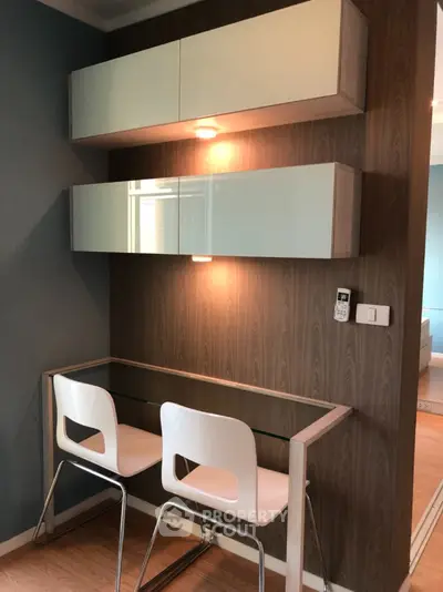 Modern study nook with sleek glass desk and stylish chairs in contemporary apartment
