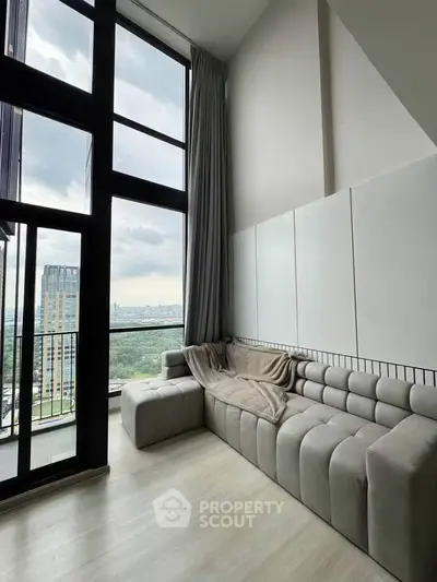 Spacious modern living room with floor-to-ceiling windows and stunning city view