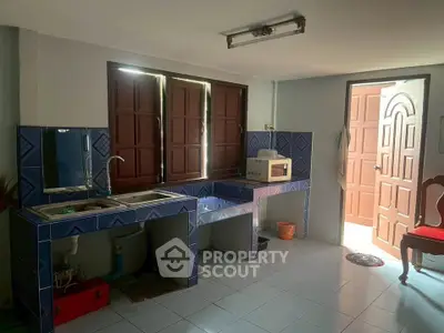 Charming kitchen with open layout and natural light, featuring tiled countertops and a cozy atmosphere.