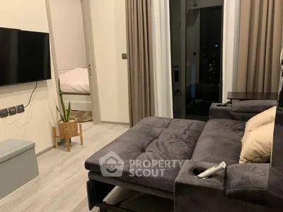 Modern living room with cozy sofa and view into a stylish bedroom