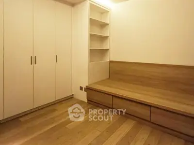 Minimalist bedroom with built-in storage and wooden flooring