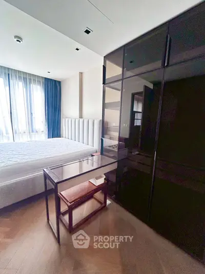 Modern bedroom with sleek black wardrobe and large window for natural light