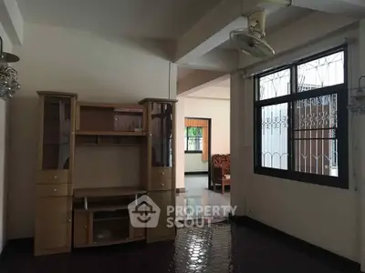 Spacious living room with wooden entertainment unit and large window