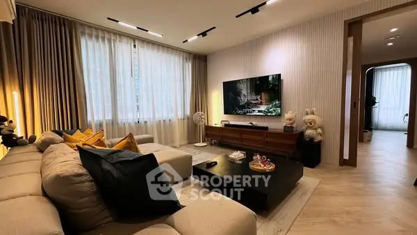 Luxurious living room with modern decor, plush sofa, and large TV for ultimate relaxation.