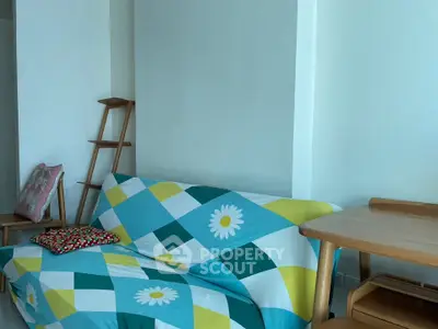 Cozy living room with colorful sofa and wooden furniture, perfect for relaxation.