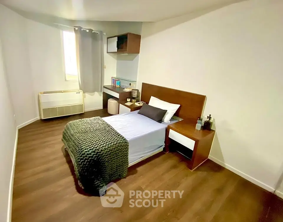 Cozy minimalist bedroom with wooden flooring and modern furniture