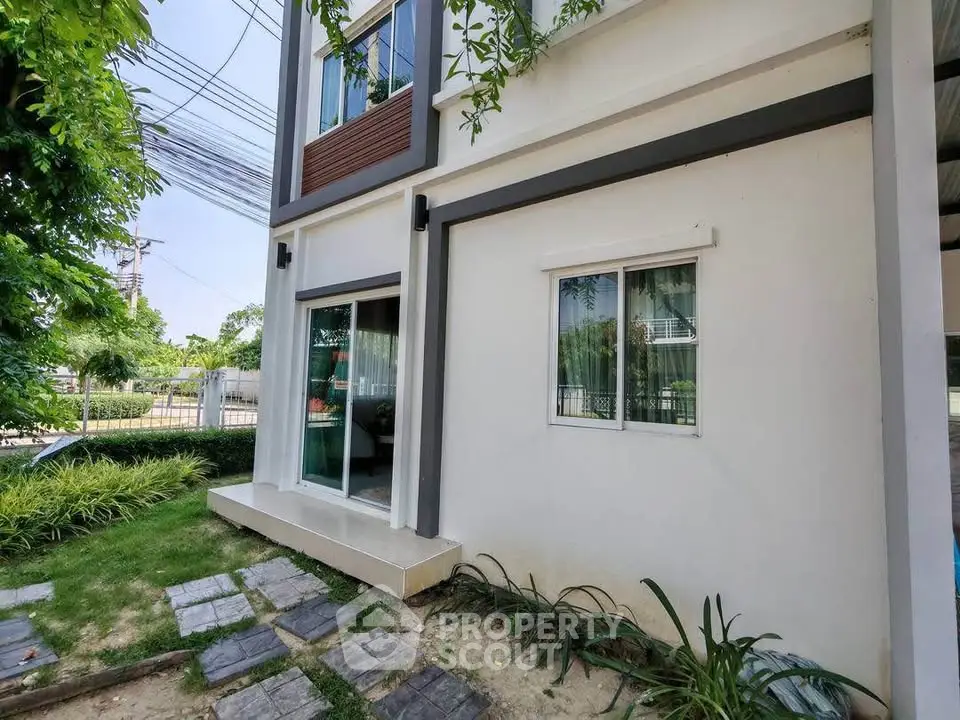 Modern building exterior with lush garden and pathway