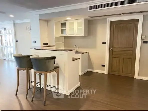 Modern kitchen with open layout and stylish bar stools in a spacious apartment.