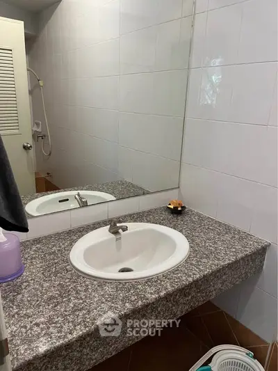 Modern bathroom with granite countertop and large mirror