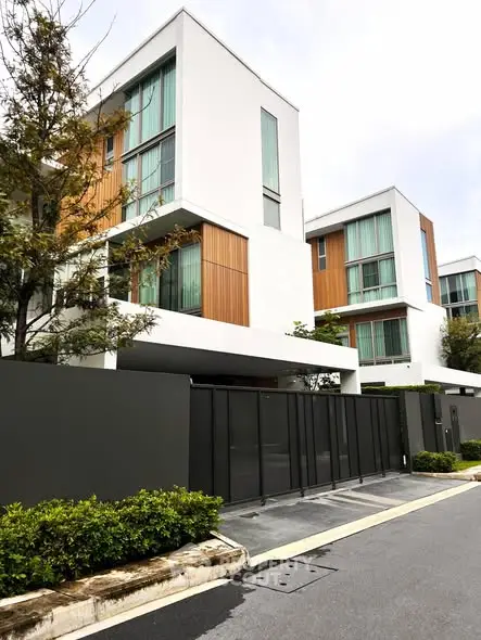 Modern multi-story residential building with sleek design and lush greenery.