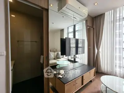 Modern living room with large windows and stylish furniture in a high-rise apartment.