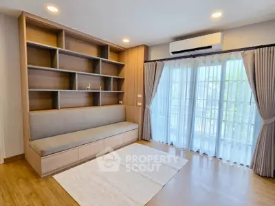 Modern living room with built-in shelves and large window for natural light.