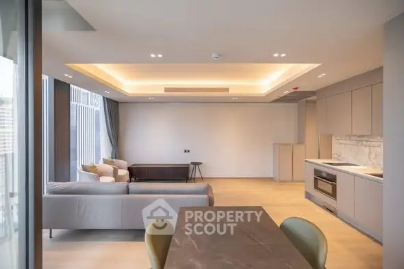 Spacious modern living room with open kitchen and elegant lighting