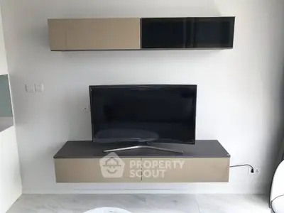 Modern living room with sleek TV setup and stylish wall-mounted cabinets.