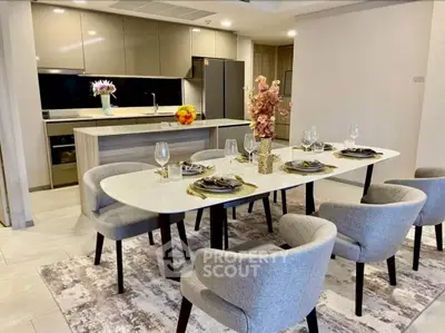 Modern dining area with elegant table setting and open kitchen layout.