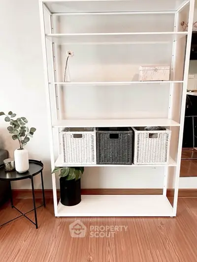 Modern interior with stylish shelving unit and decorative plants in a cozy living space.