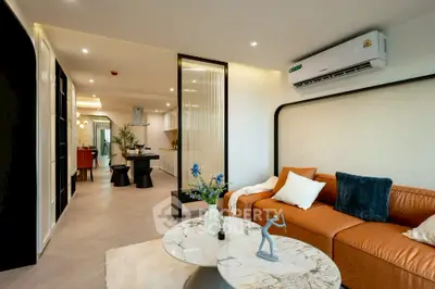 Modern living room with stylish furniture and open layout, featuring air conditioning and elegant decor.