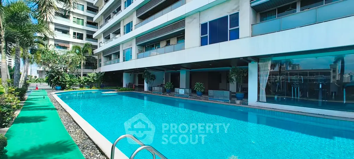 Luxurious apartment complex with a stunning outdoor pool and lush greenery, perfect for relaxation and leisure.