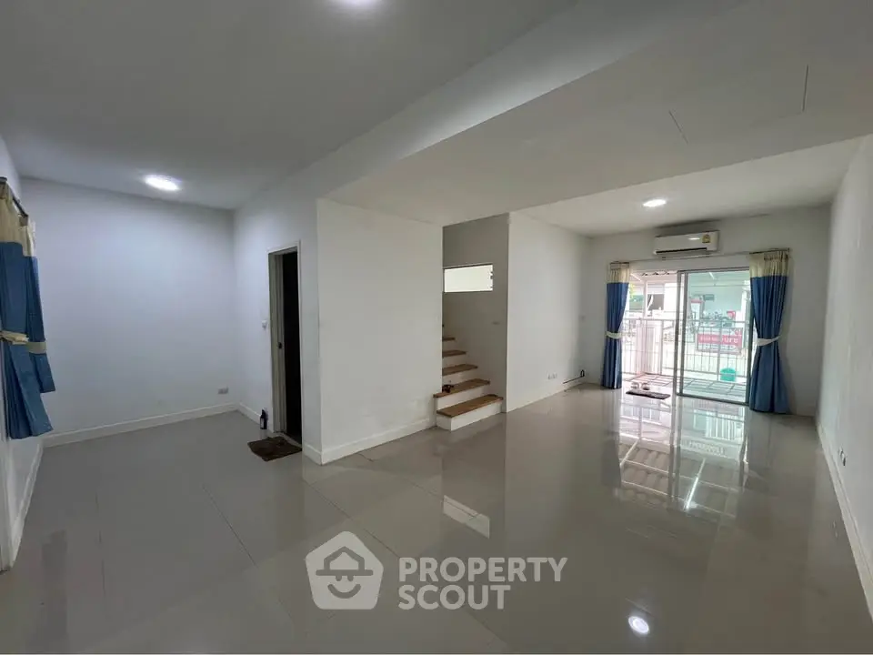 Spacious modern living room with large windows and sleek tile flooring