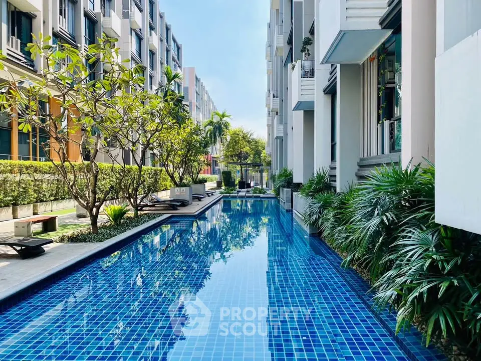 Luxurious residential pool area with modern architecture and lush greenery.