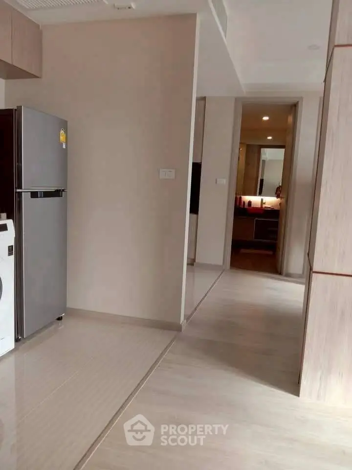 Modern apartment hallway with sleek design and visible kitchen appliances.