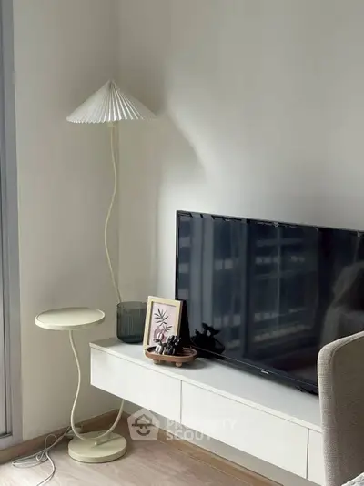 Modern living room with stylish lamp and TV setup on sleek console.