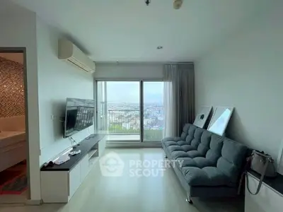 Modern living room with city view, featuring sleek furniture and large windows for natural light.