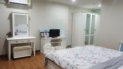 Spacious bedroom with elegant white furniture and cozy bedding in modern apartment.