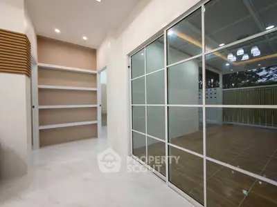 Modern interior with sliding glass doors and built-in shelving, featuring elegant lighting and spacious design.