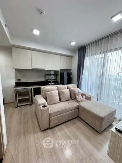 Modern living room with open kitchen and large windows in a stylish apartment.