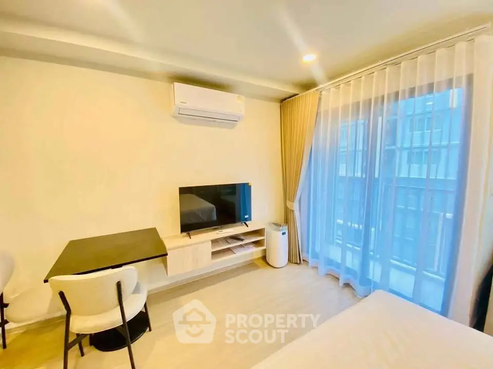 Modern living room with air conditioning and large window in a stylish apartment.