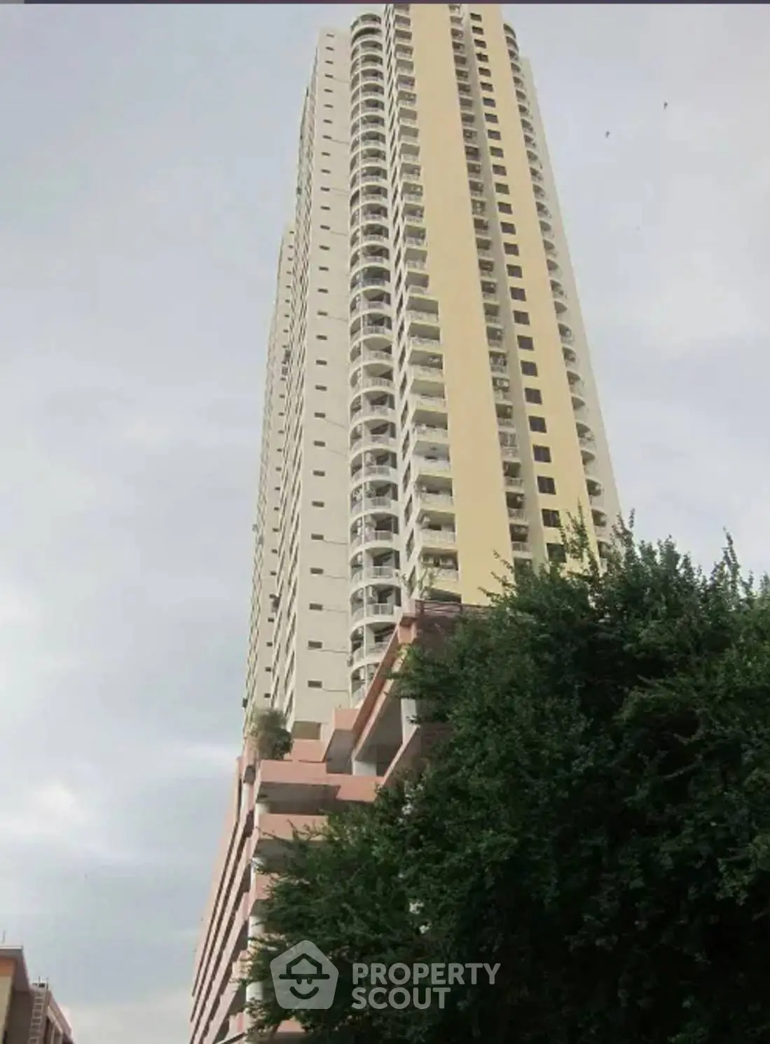 Stunning high-rise building with modern architecture and lush greenery, perfect for urban living.