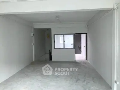Spacious unfurnished room with concrete floor and white walls, ideal for customization.