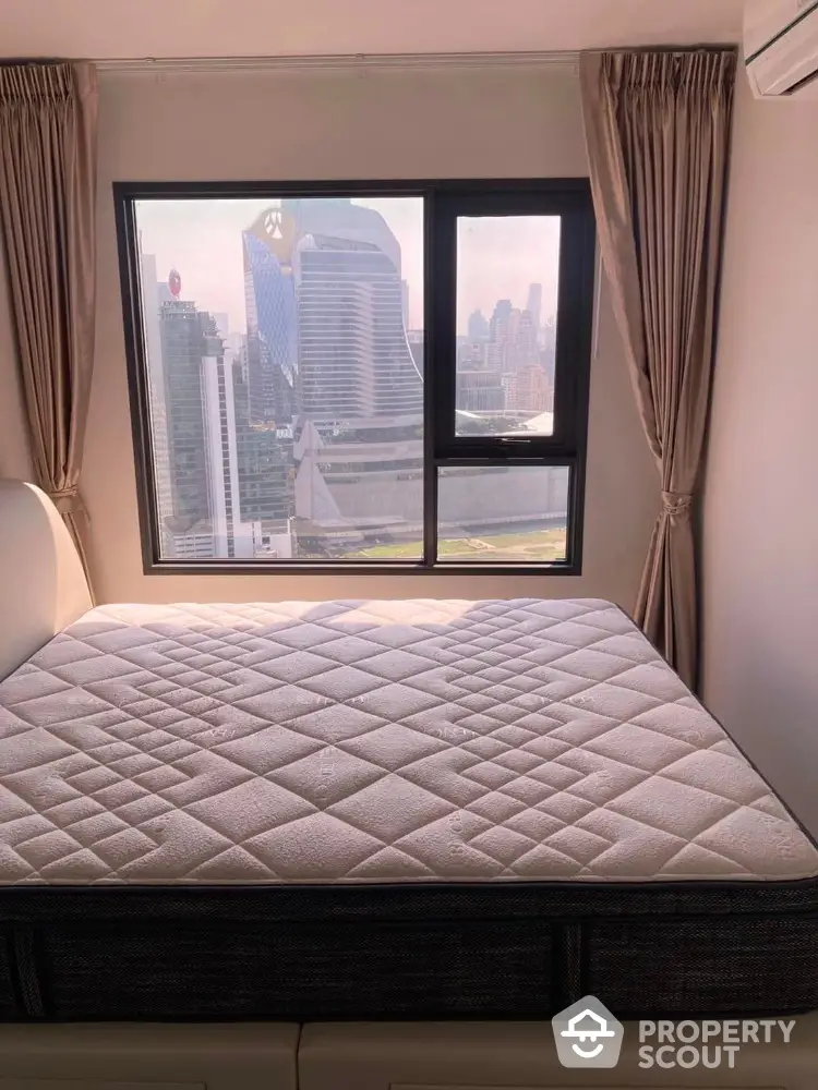 Modern bedroom with city view and large window in high-rise apartment