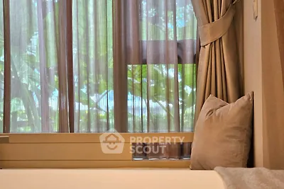 Cozy bedroom with elegant curtains and lush greenery view, perfect for relaxation.