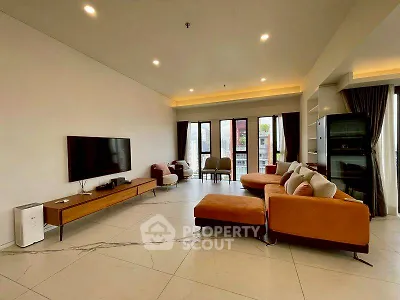 Spacious modern living room with stylish furniture and large windows offering natural light.