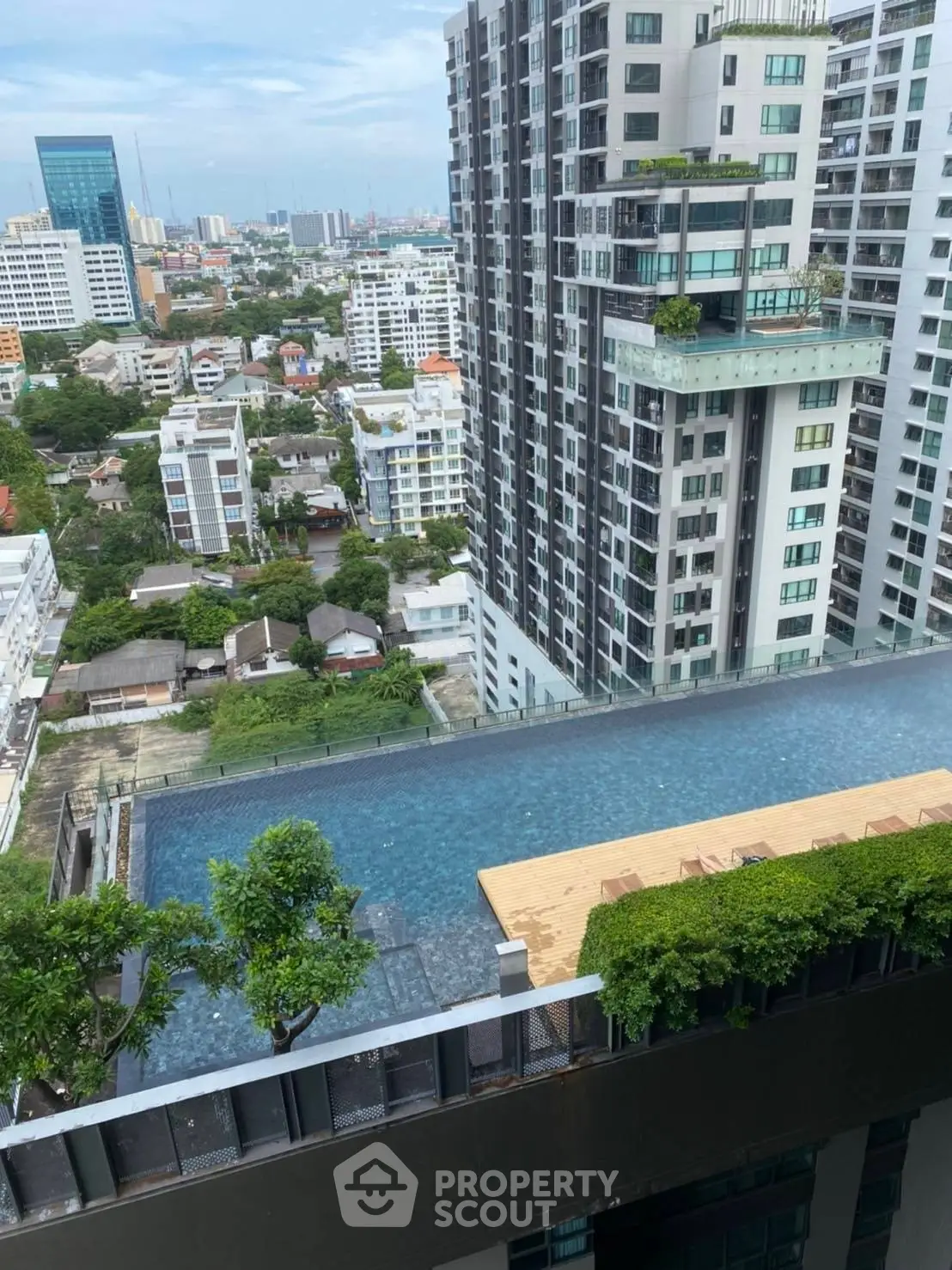Stunning rooftop pool with panoramic city views in modern high-rise building.