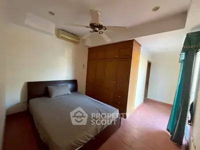 Spacious bedroom with built-in wardrobe and ceiling fan in modern apartment