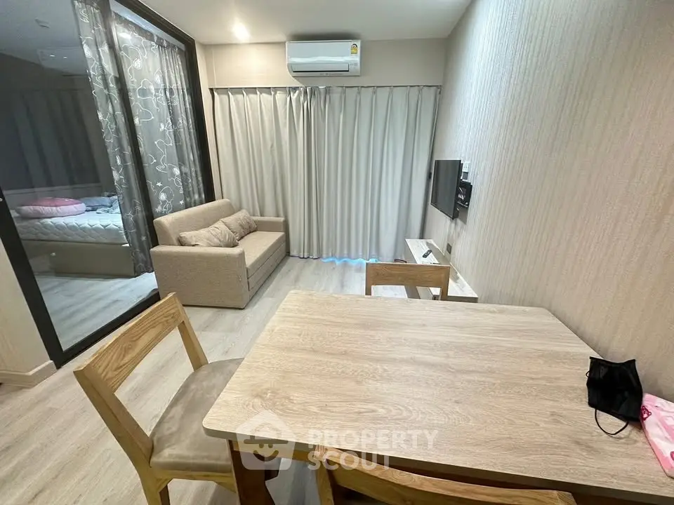 Modern living room with cozy sofa, dining table, and wall-mounted TV in stylish apartment.
