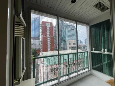 Urban balcony with city view, featuring safety netting and modern architecture.